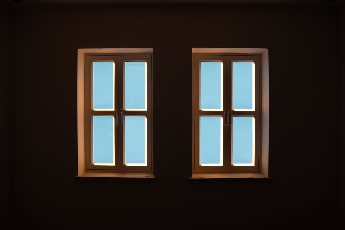 Two Flat 22X artificial windows glowing in a dark room, warm frame light